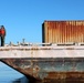 Decommissioned World War II-era fuel barge undergoing a maneuverability test to determine its towing capabilities.