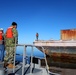 Decommissioned World War II-era fuel barge undergoing a maneuverability test to determine its towing capabilities.