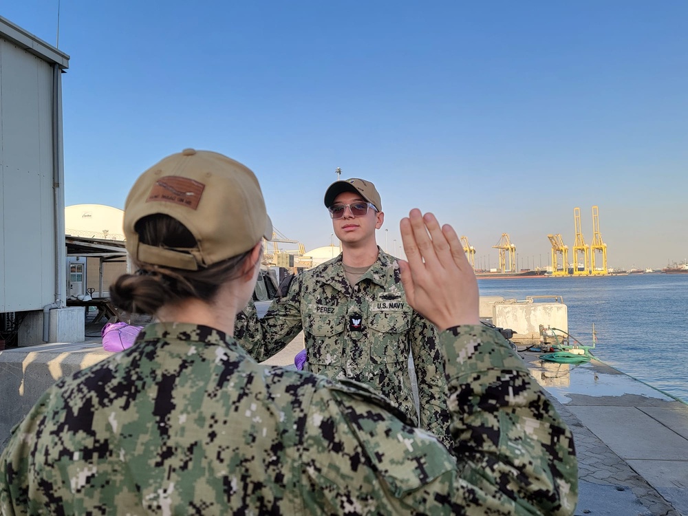 Gunner’s Mate 3rd Class Adriano Perez assigned to Maritime Expeditionary Security Squadron (MSRON) 2 Alpha company reenlists on the pier during his United Arab Emirates deployment.