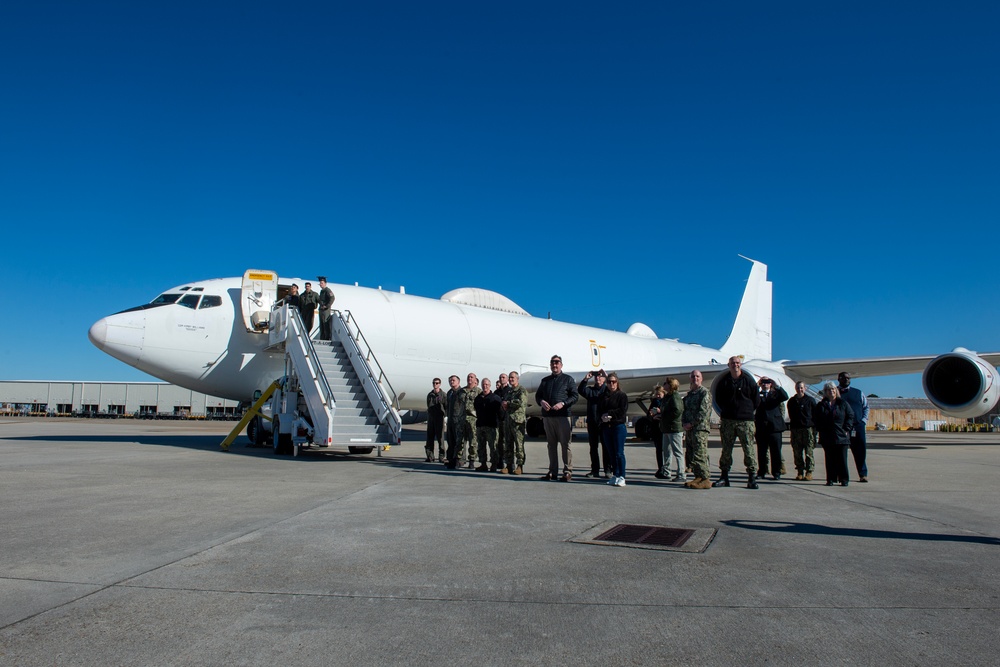 Members of the USSTRATCOM Component Commanders Conference wait beside an E-6B Mercury to view a flyover by an Air Force B52, Feb. 5, 2024.