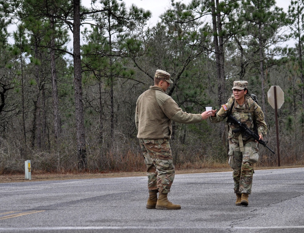 Best Squad cadre provide water to ruck march competitors during Best Squad challenge