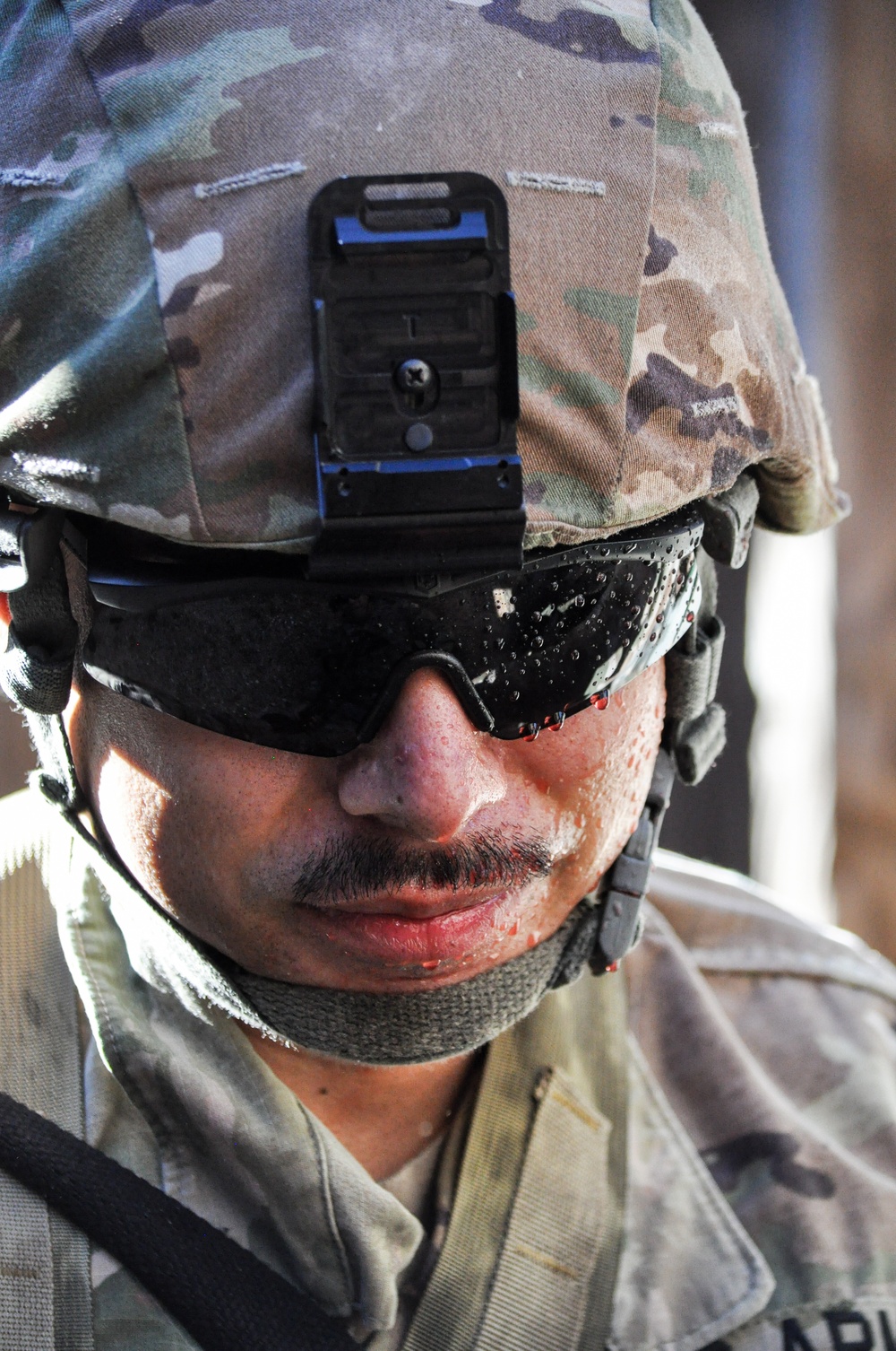 Simulated casualty blood drips from the glasses of a CA NCO during training