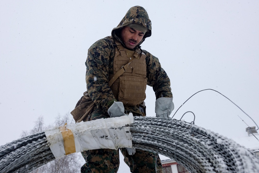 U.S. Marines with 2nd Marine Aircraft Wing set up concertina wire in preparation for Exercise Nordic Response 24