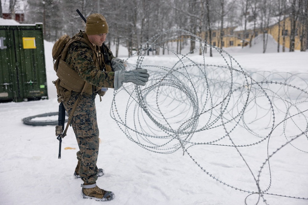 U.S. Marines with 2nd Marine Aircraft Wing set up concertina wire in preparation for Exercise Nordic Response 24