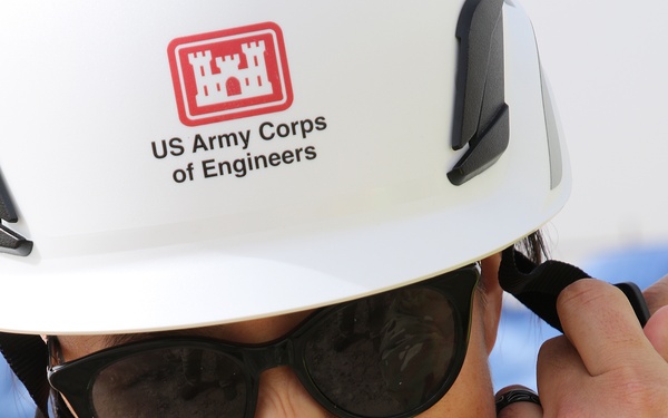 TAM Employee gets help with helmet strap.