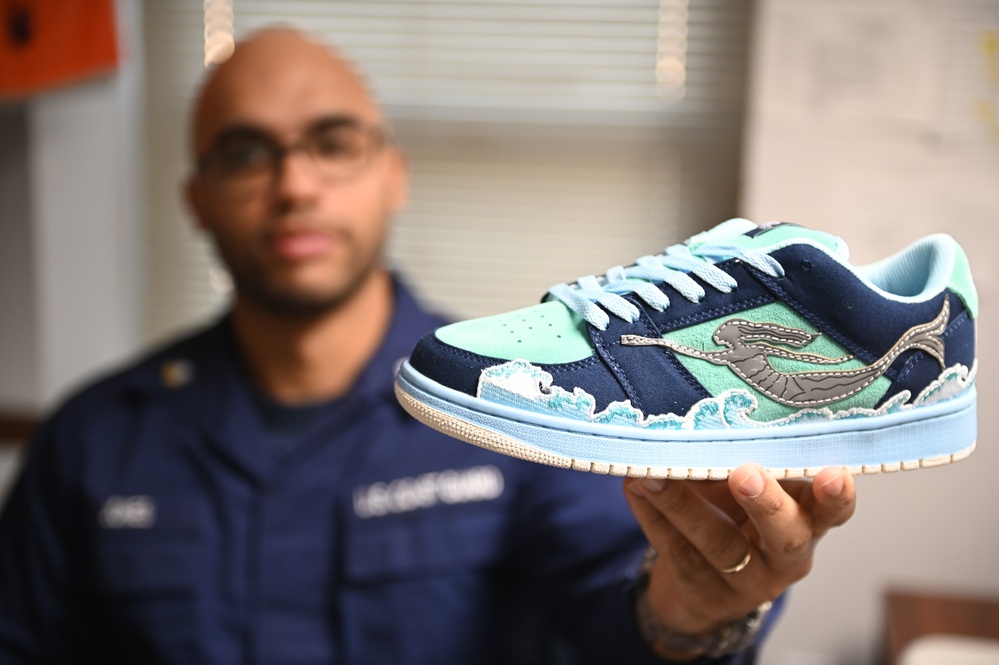 Petty Officer Second Class Kenneth Jones presents his own custom created sneaker from an online competition in Norfolk, Virginia, Nov. 29, 2023.