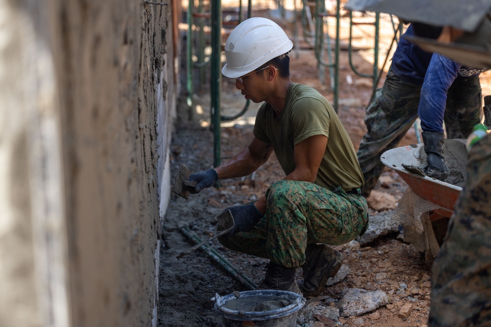 Cobra Gold 24; Marines with Marine Wing Support Squadron 171 apply stucco at the Ban Prakaet School