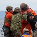 Navy Divers assist astronaut out of crew module test article during Underway Recovery Test 11