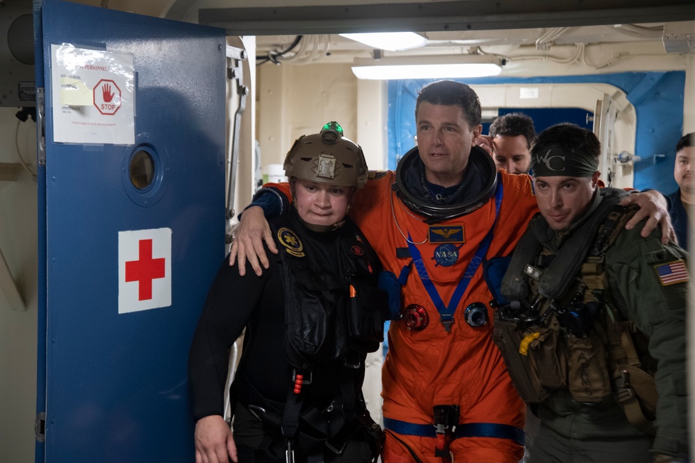 Helicopter Sea Combat Squadron 23 Sailors assist astronauts to medical facilities during Underway Recovery Test 11