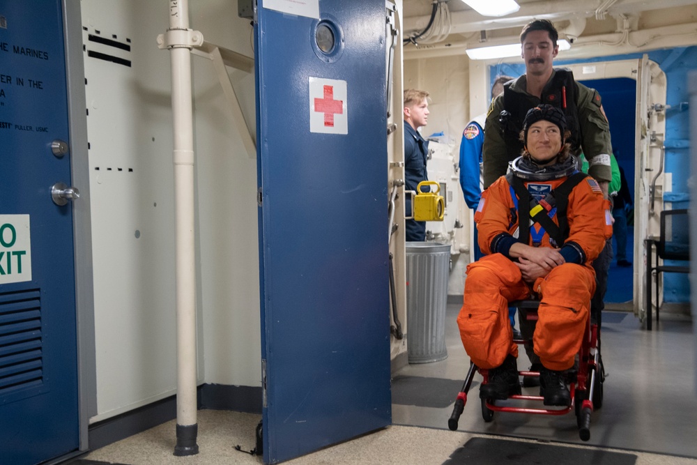 Helicopter Sea Combat Squadron 23 Sailor assists astronauts to medical facilities during Underway Recovery Test 11