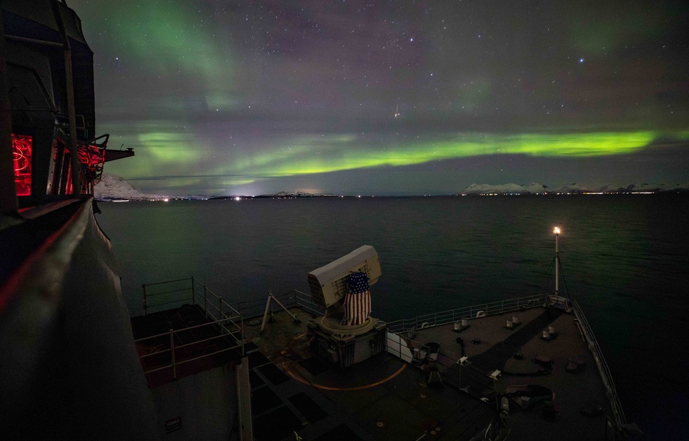 USS Gunston Hall passes under the northern lights during Steadfast Defender 24