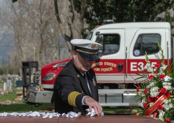Former Travis Air Force Base fire Chief John Speakman lays a white glove on the casket of  former Travis AFB assistant fire Chief Robert Dittmer