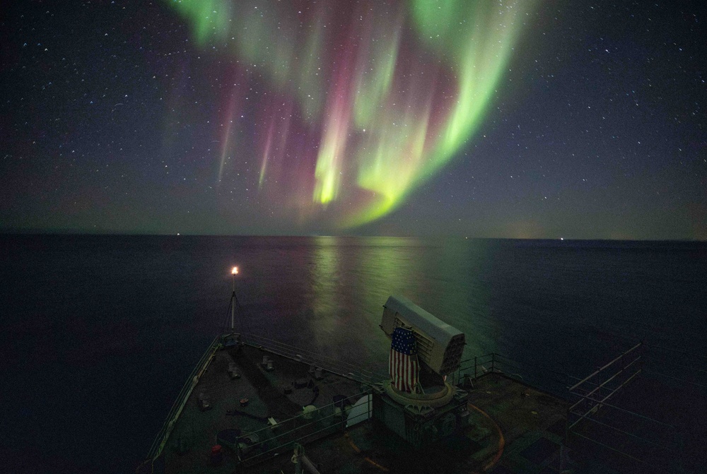 USS Gunston Hall passes under the northern lights during Steadfast Defender 24