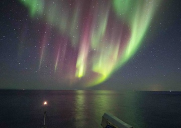 USS Gunston Hall passes under the northern lights during Steadfast Defender 24