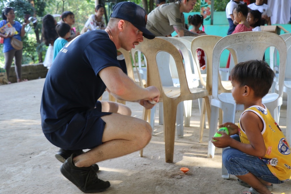 USS Manchester (LCS 14), Philippine Navy Sailors visit Agusuhin Elementary School in Subic Bay