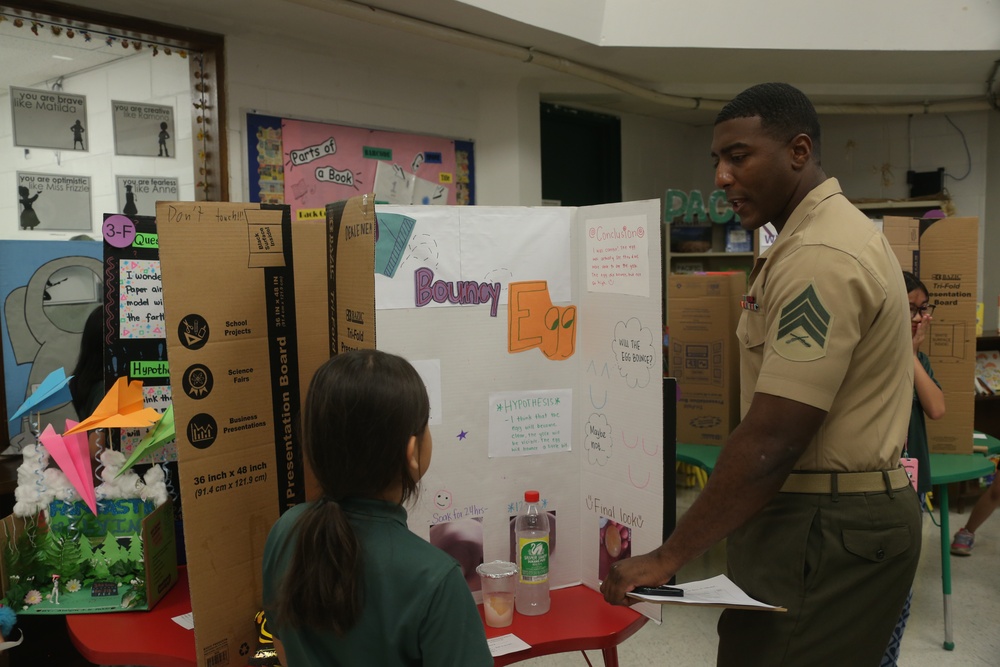 U.S. Marines stationed at Marine Corps Base Camp Blaz volunteer at Finegayan Elementary School science fair