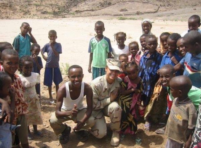 Retired Tech. Sgt. Daylena Ricks, photojournalist, poses for a picture with local nationals while on a humanitarian mission in Addis, Ethiopia