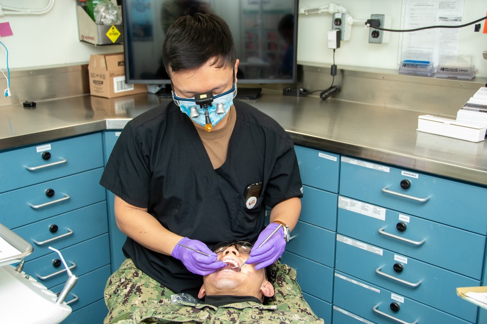 USS Ronald Reagan (CVN 76) Sailors conduct a dental examination