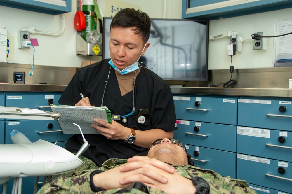 USS Ronald Reagan (CVN 76) Sailors conduct a dental examination