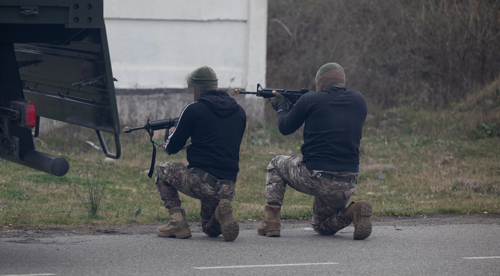 Georgian guard and Georgian special operations forces soldiers act as opposing forces during an STX with MARSOC Marines