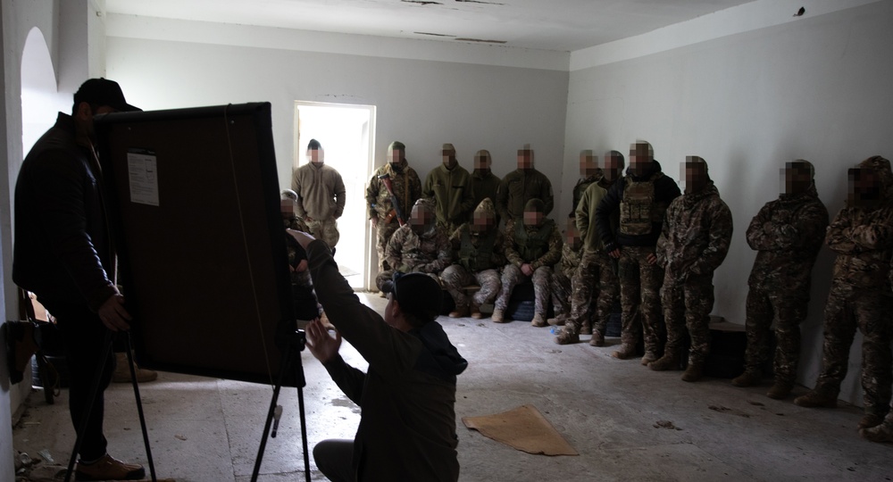 A U.S. MARSOC Marine Raider instructs Georgian and Spanish special operations forces soldiers on demolition tactics during Trojan Footprint 24