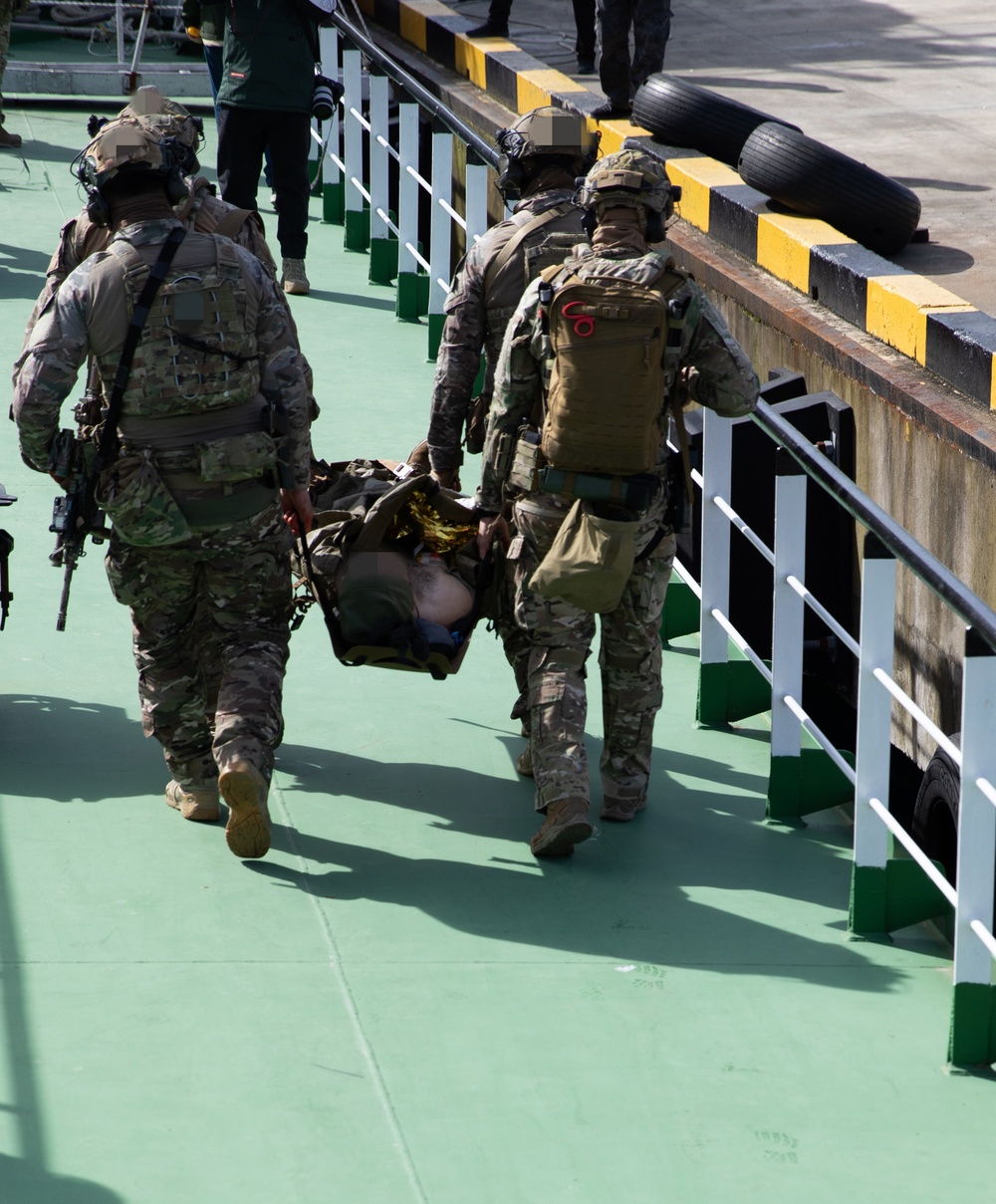 Georgian and Spanish special operations forces soldiers move a simulated casualty to higher care during Trojan Footprint 24