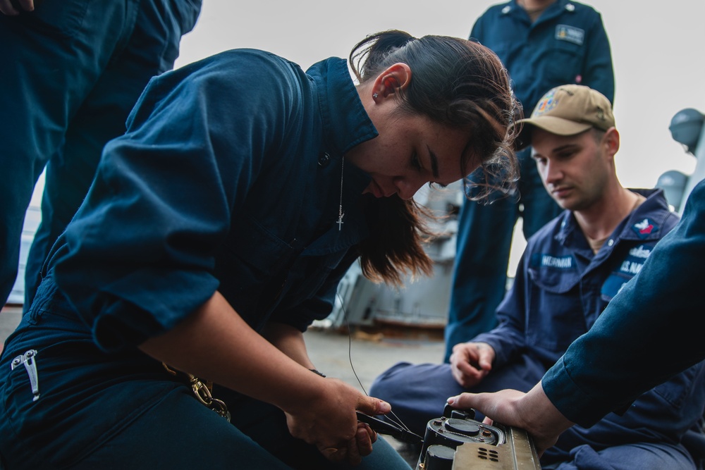 Sailor conducts maintenance on the 25mm gun