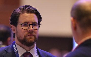 Matthew Loftus meets with visitors to the FEHRM kiosk at the HIMSS Conference