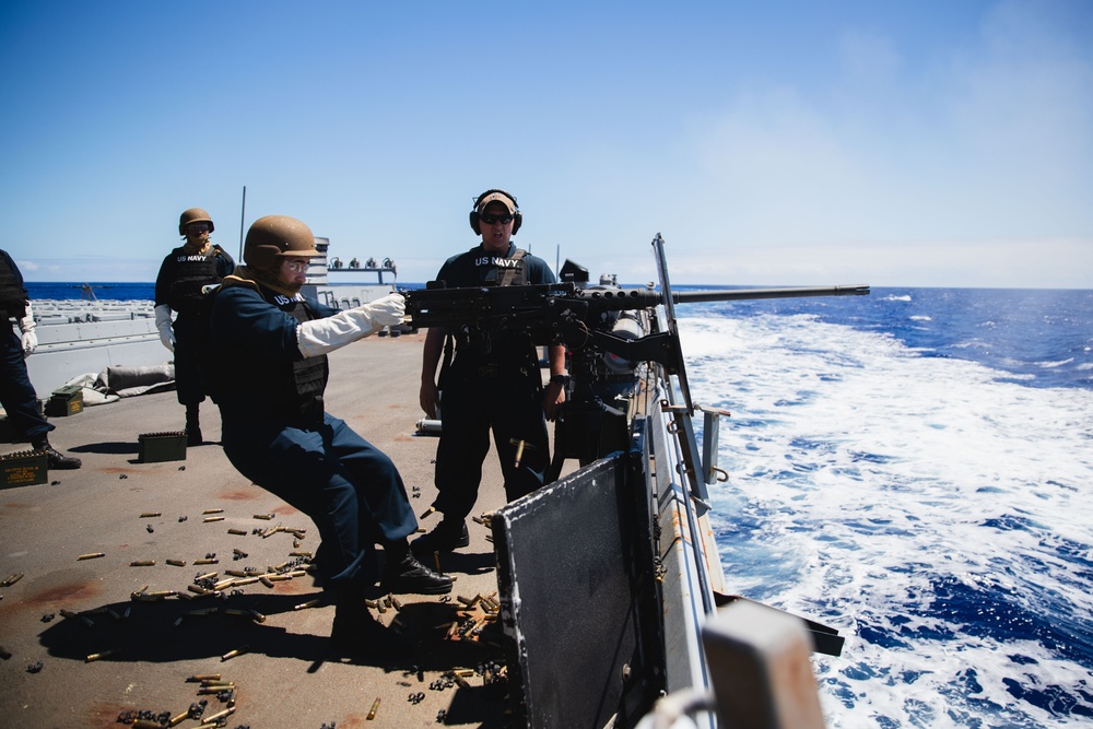Sailor fires M2HB machine gun