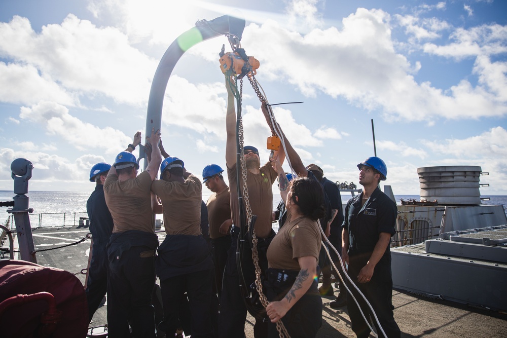 Sailors prepare to hoist torpedo