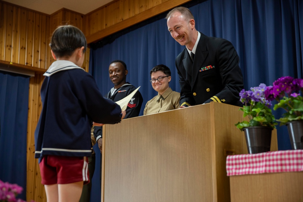 Graduation: Volunteers from Marine Corps Air Station Iwakuni hand out graduation certificates