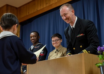 Graduation: Volunteers from Marine Corps Air Station Iwakuni hand out graduation certificates