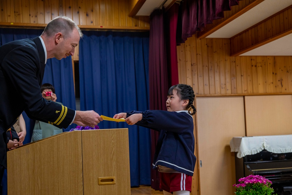 Graduation: Volunteers from Marine Corps Air Station Iwakuni hand out graduation certificates