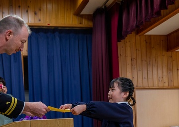 Graduation: Volunteers from Marine Corps Air Station Iwakuni hand out graduation certificates