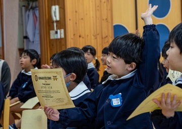 Graduation: Volunteers from Marine Corps Air Station Iwakuni hand out graduation certificates