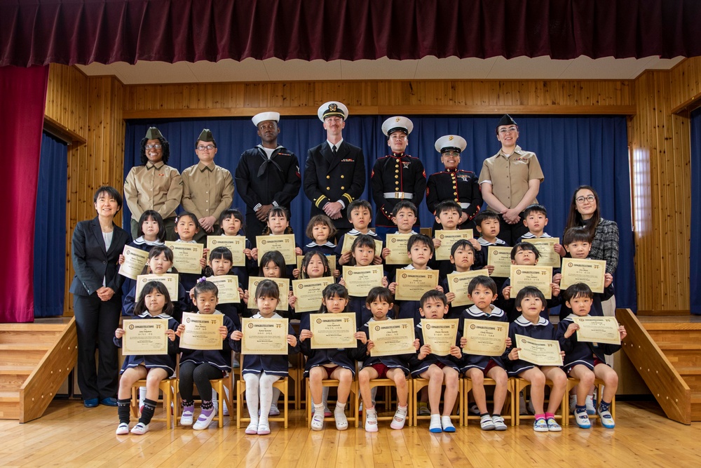 Graduation: Volunteers from Marine Corps Air Station Iwakuni hand out graduation certificates