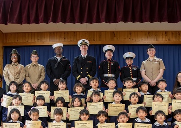 Graduation: Volunteers from Marine Corps Air Station Iwakuni hand out graduation certificates