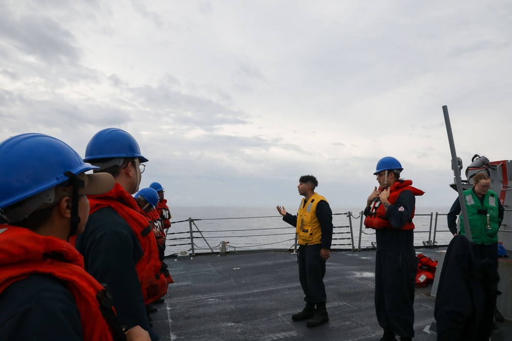 Sailors aboard the USS Howard conduct a replenishment-at-sea with USNS Yukon in the Philippine Sea