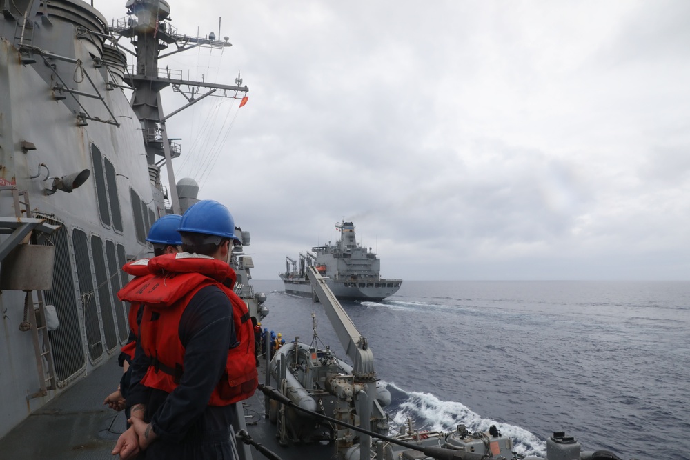 Sailors aboard the USS Howard conduct a replenishment-at-sea with USNS Yukon in the Philippine Sea
