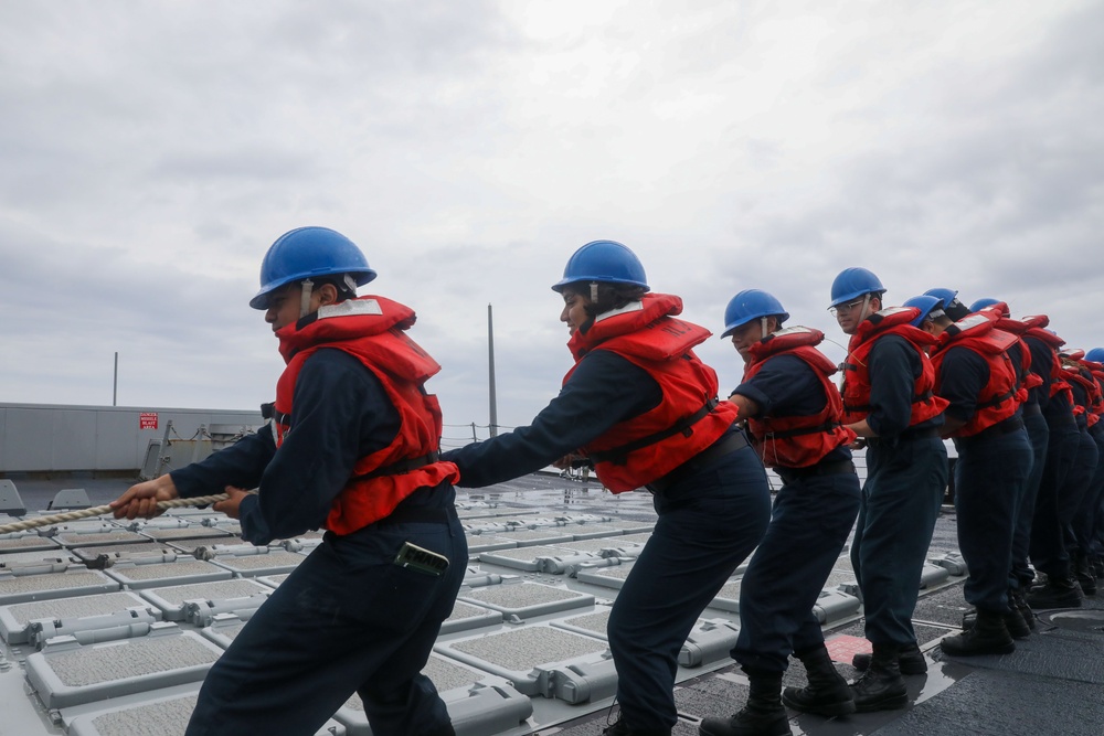 Sailors aboard the USS Howard conduct a replenishment-at-sea with USNS Yukon in the Philippine Sea