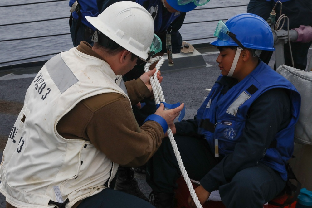 Sailors aboard the USS Howard conduct a replenishment-at-sea with USNS Yukon in the Philippine Sea