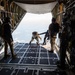 Special forces service members jump out of the back of a C-130 Hercules aircraft
