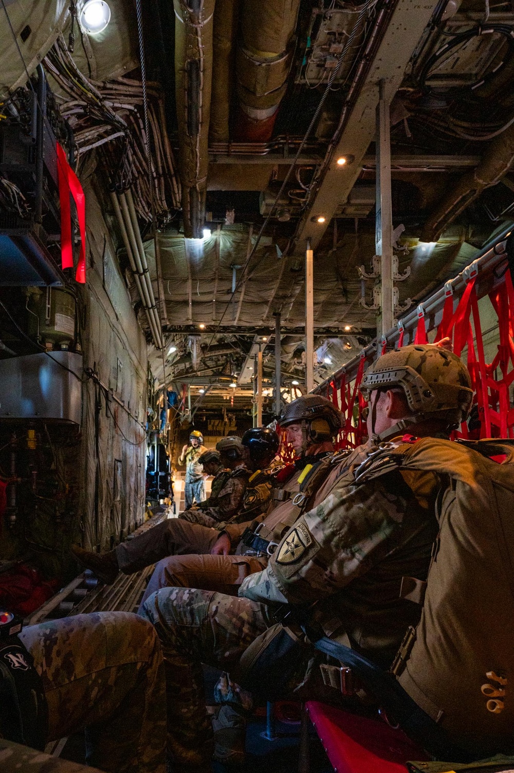 Special forces service members jump out of the back of a C-130 Hercules aircraft