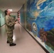 Sailor volunteers to paint murals at the Huntington Hall Naval Berthing Facility