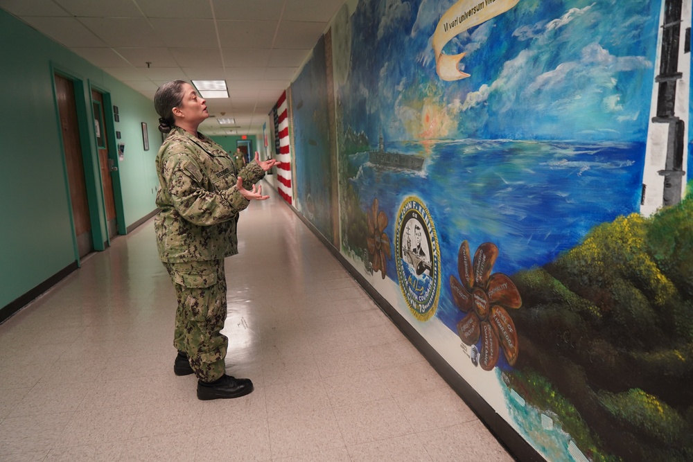 Sailor volunteers to paint murals at the Huntington Hall Naval Berthing Facility