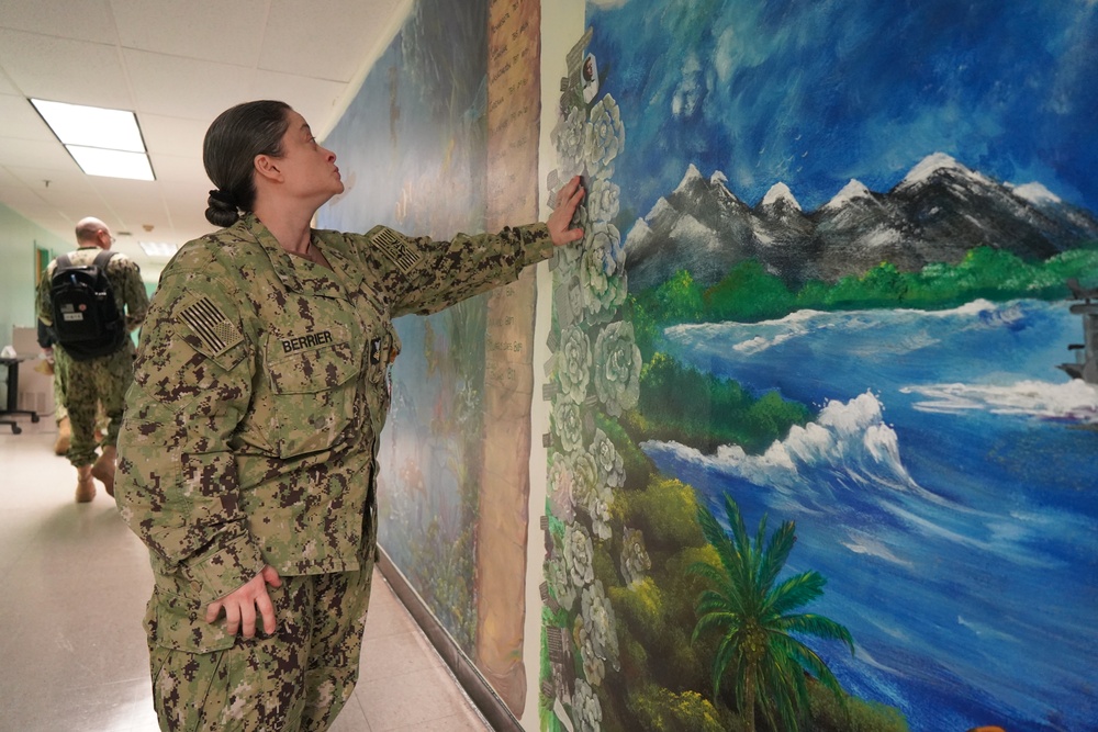 Sailor volunteers to paint murals at the Huntington Hall Naval Berthing Facility