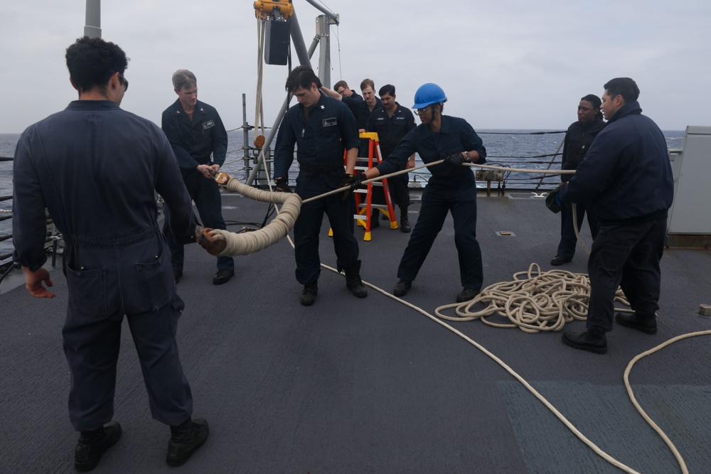 Sailors aboard the USS Howard prepare for a torpedo upload in the Philippine Sea