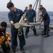 Sailors aboard the USS Howard prepare for a torpedo upload in the Philippine Sea