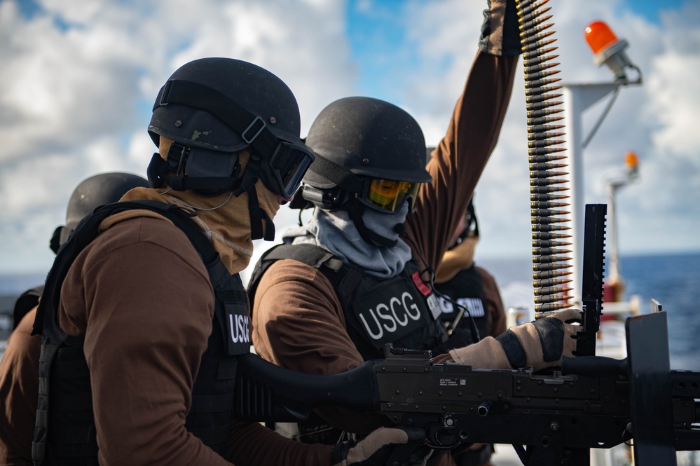 Coast Guard members load a gun