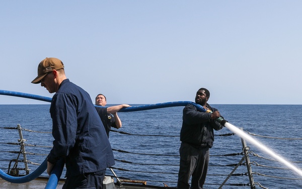 Sailors aboard the USS Howard conduct a freshwater wash down in the North Pacific Ocean